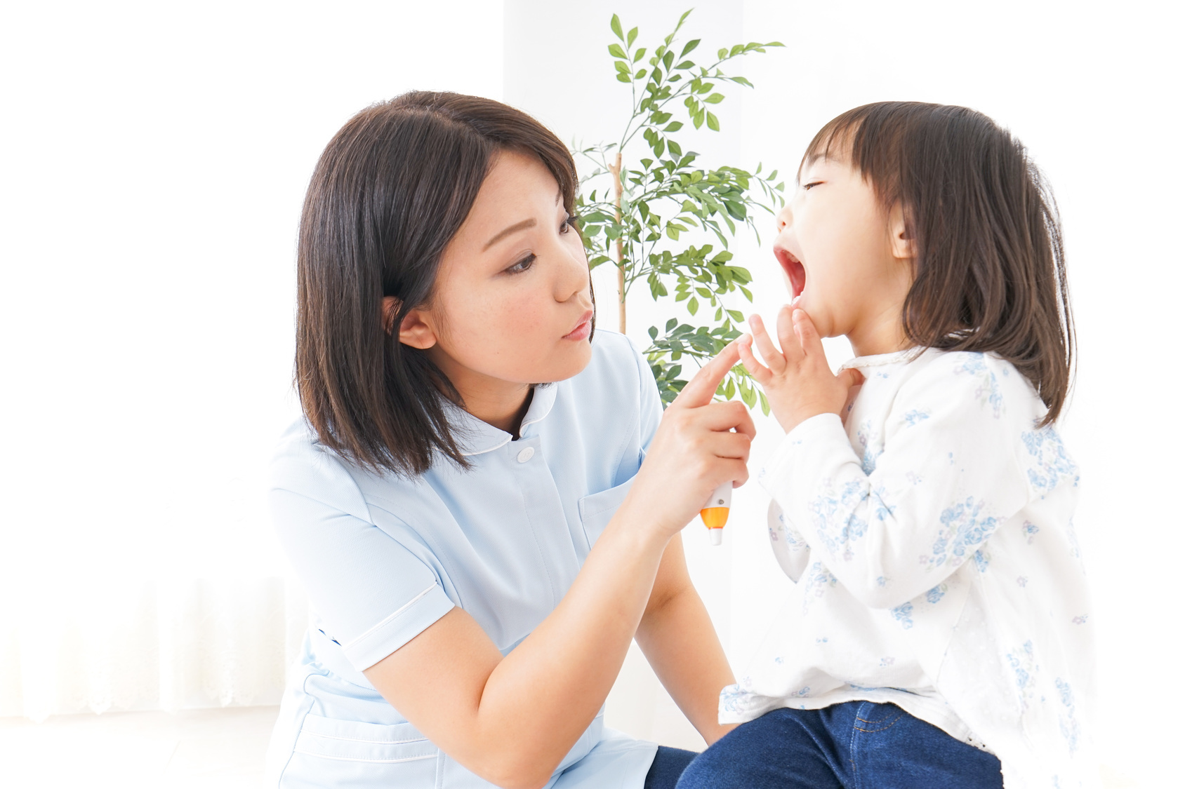 子どもの口の中を診ている歯科医師